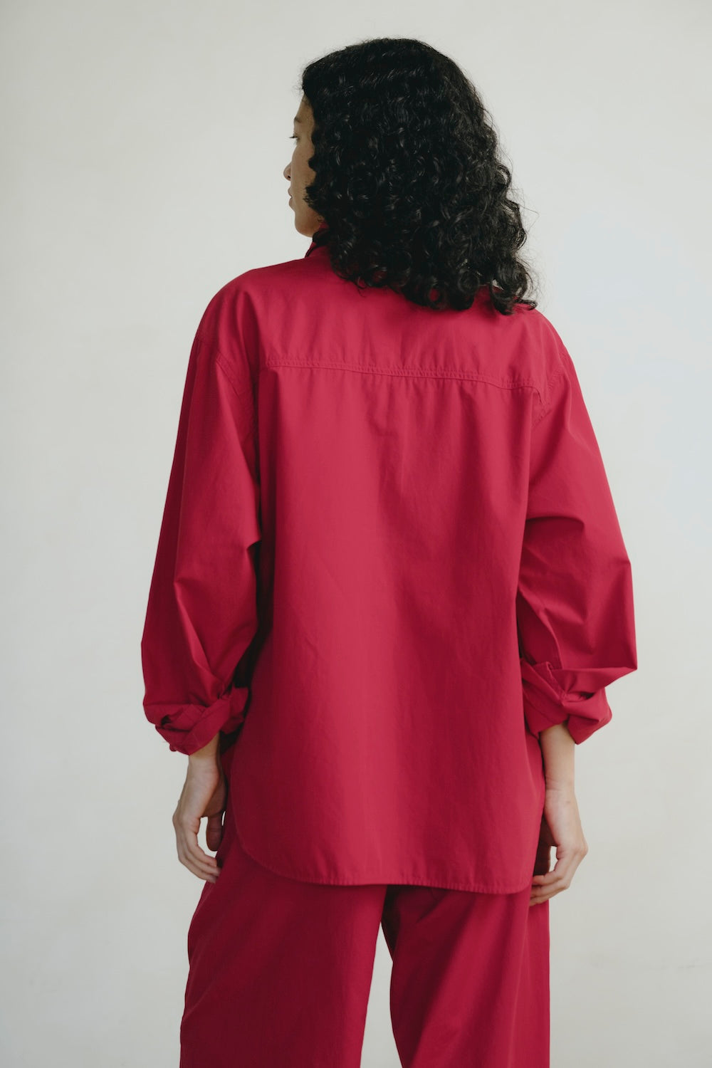 Person wearing a red outfit against a plain background